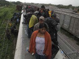 Migrantes de origen centroamericano permanecen arriba de un vagón de ferrocarril en su tránsito hacia Estados Unidos. AP  /