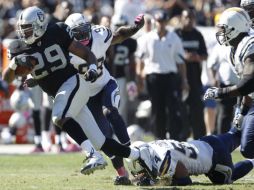 Los jugadores de San Diego no pudieron impedir que Michael Bush (izq.) hiciera la anotación del triunfo. AP  /