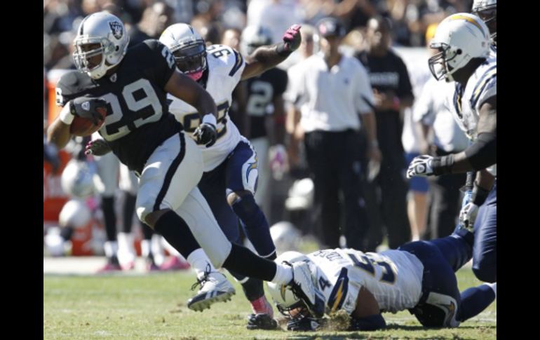 Los jugadores de San Diego no pudieron impedir que Michael Bush (izq.) hiciera la anotación del triunfo. AP  /