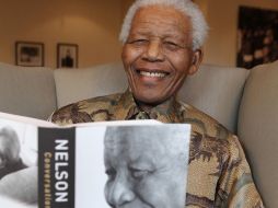 El ex presidente de Sudáfrica Nelson Mandela posa sonriente con un ejemplar de su último libro. AP  /