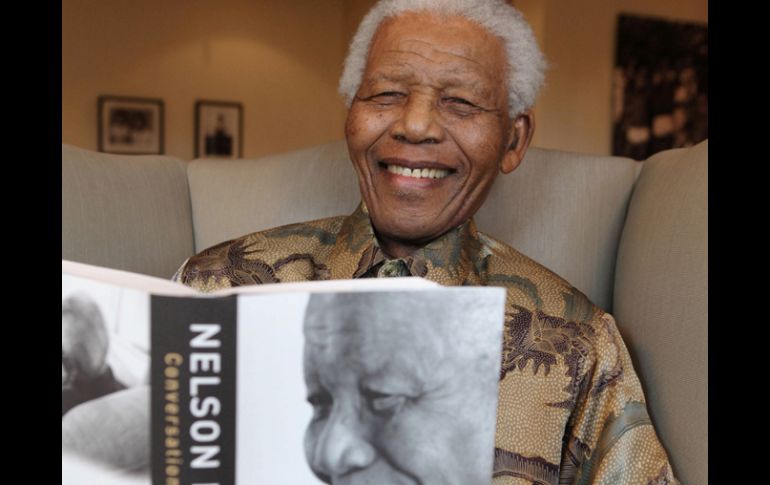 El ex presidente de Sudáfrica Nelson Mandela posa sonriente con un ejemplar de su último libro. AP  /