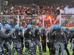 Policía italiana toman posición frente a aficionados serbios que permanecen en las graderías. EFE  /