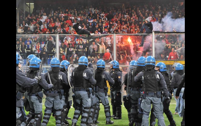 Policía italiana toman posición frente a aficionados serbios que permanecen en las graderías. EFE  /