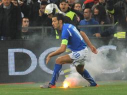 El italiano Gianluca Zambrotta por poco recibe directamente una de las bengalas. EFE  /