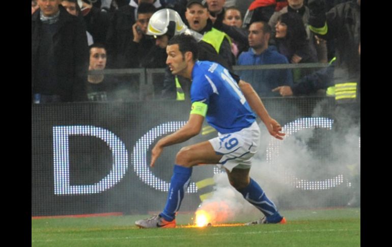 El italiano Gianluca Zambrotta por poco recibe directamente una de las bengalas. EFE  /