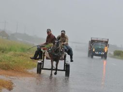 Dos hombres viajan en una carreta bajo una intensa lluvia provocada por la proximidad del huracán ‘‘Paula’’. EFE  /