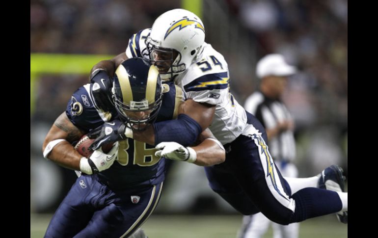 Michael Hoomanawanui (86) aguanta el intento de bloqueo de Stephen Cooper (54) de los Cargadores de San Diego. AP  /