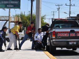 Policias estatales se resguardan durante un enfrentamiento con un miembro de una empresa de seguridad privada que tomó dos rehenes. EFE  /