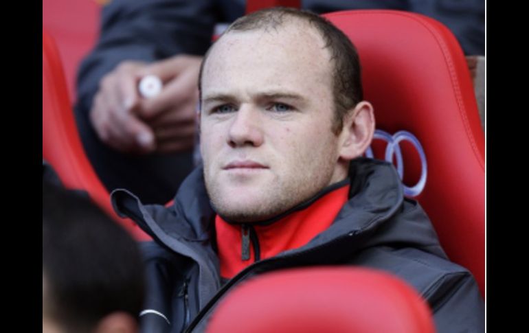 El jugador inglés Wayne Rooney ve la actuación del Manchester United desde la banca. AP  /