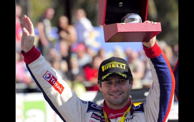 El piloto francés Sebastien Loeb festeja su triunfo levantando su trofeo de el Rally de Cataluña. AFP  /