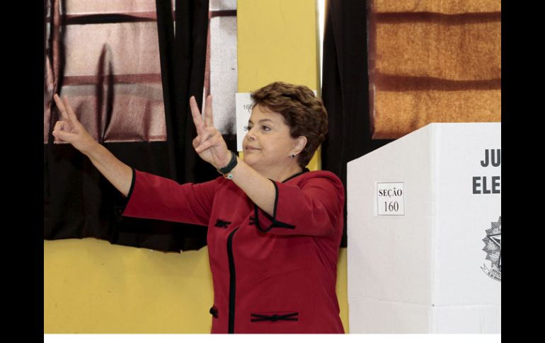 La candidata oficialista Dilma Rousseff votó en el colegio Santos Dumontt, y salió haciendo con los dedos la 'V' de victoria. EFE  /