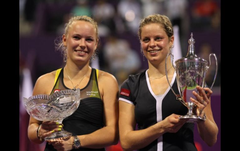 Las tenistas Kim Clijsters (der.) y Caroline Wozniacki posan con sus trofeos. AFP  /