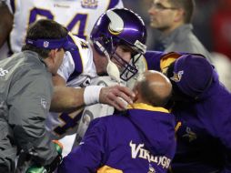 Brett Favre tuvo que salir ayudado por los médicos de los Vikingos. AP  /