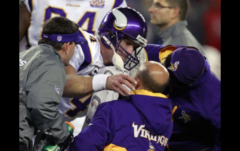 Brett Favre tuvo que salir ayudado por los médicos de los Vikingos. AP  /