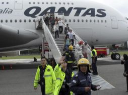 Bomberos y brigadistas asisten a los pasajeros como medida de precaución. AP  /