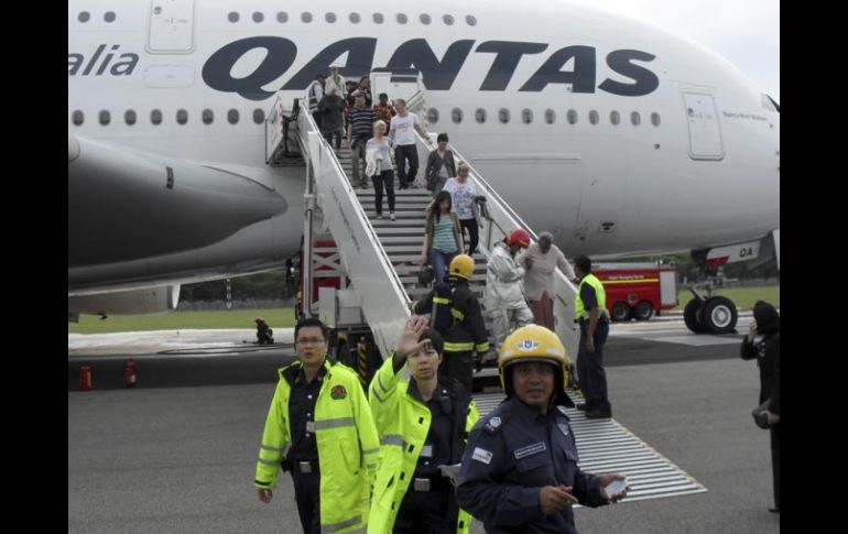 Bomberos y brigadistas asisten a los pasajeros como medida de precaución. AP  /