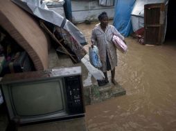 Una mujer espera a cruzar una calle inundada de Leogane, Haití. AP  /