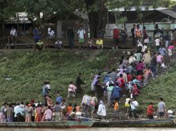 Refugiados birmanos regresan a su país desde Tailandia, a donde huyeron a causa de un ataque rebelde. EFE  /