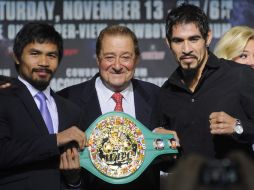 Margarito (der.) sostiene junto a Pacquiao (izq.) el cinturón que disputarán mañana. EFE  /