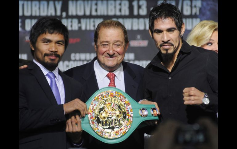 Margarito (der.) sostiene junto a Pacquiao (izq.) el cinturón que disputarán mañana. EFE  /