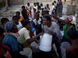 Haitianos  en espera para recoger el agua que se utiliza para limpiar y cocinar en Puerto Príncipe. AP  /