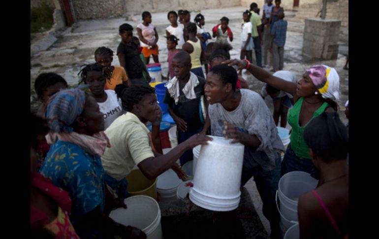 Haitianos  en espera para recoger el agua que se utiliza para limpiar y cocinar en Puerto Príncipe. AP  /