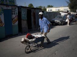 Un hombre transporta a una persona con síntomas de cólera, en Puerto Príncipe. EFE  /