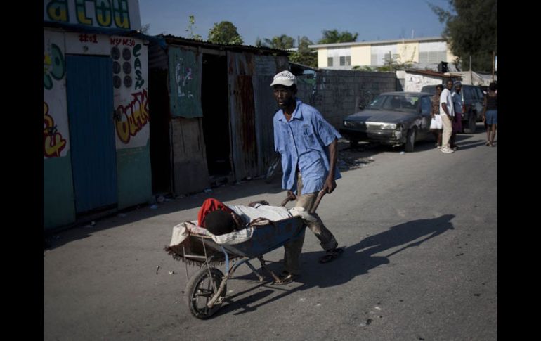 Un hombre transporta a una persona con síntomas de cólera, en Puerto Príncipe. EFE  /