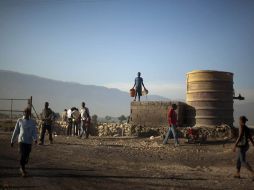 Varias personas esperan por agua en las afueras de Puerto Príncipe. AP  /