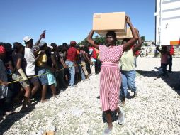 Haitianos esperan formados para recibir agua y víveres de la Cruz Roja. AFP  /