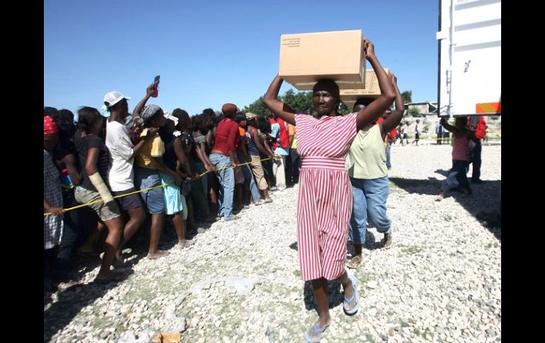 Haitianos esperan formados para recibir agua y víveres de la Cruz Roja. AFP  /