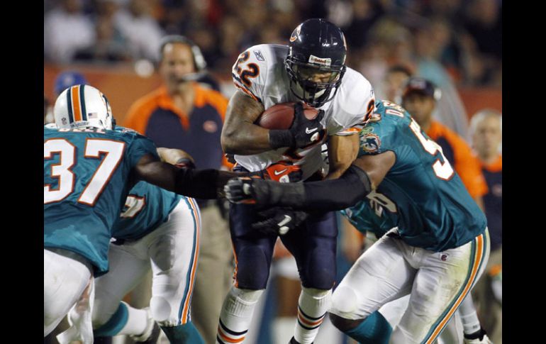 Matt Forte de los Osos es tacleado por Yeremiah Bell y Koa Misi. AP  /