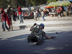 Uno de los cascos azules cae al suelo durante el enfrentamiento entre fuerzas de la ONU y haitianos. AP  /