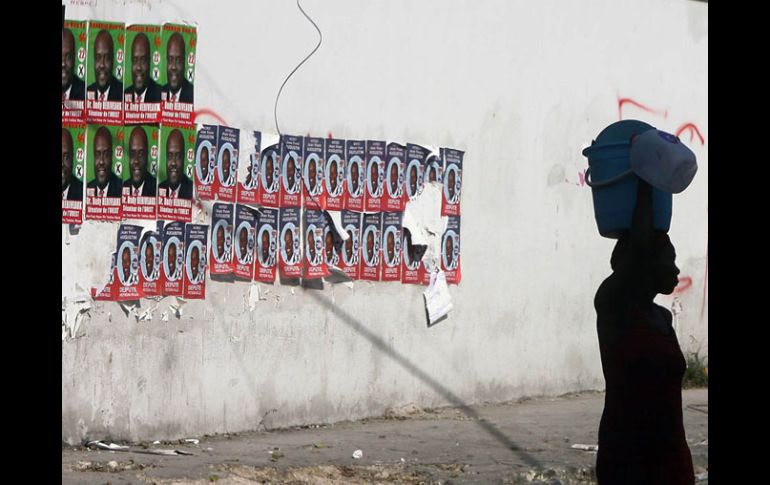 Una mujer haitiana pasa frente a una pared con propaganda electoral, e Puerto Príncipe. AFP  /