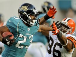 Maurice Jones-Drew domina el balon ante el ataque del rival de Cleveland. AP  /