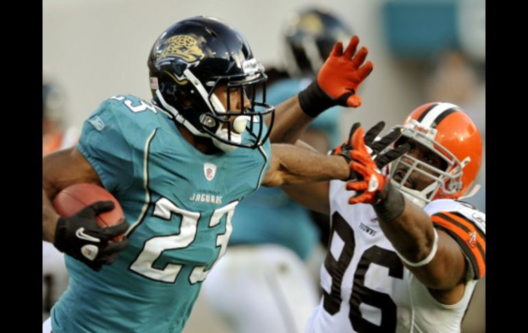 Maurice Jones-Drew domina el balon ante el ataque del rival de Cleveland. AP  /