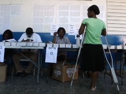 Encargados de los comicios electorales, revisan las identificaciones de los votantes en Haití. AFP  /