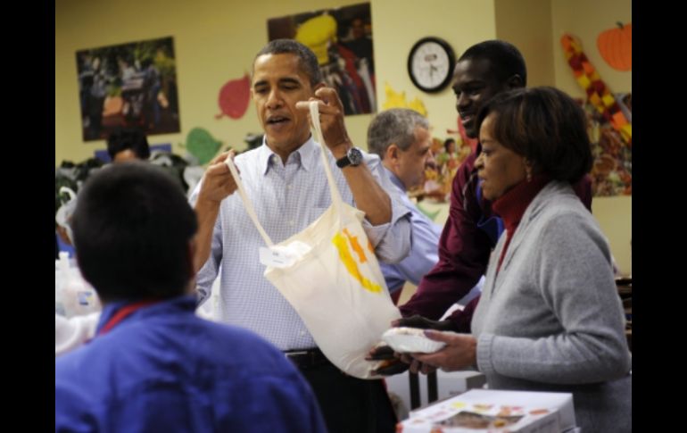 La víspera de Acción de Gracias, Obama repartió comida para gente necesitada en Washington. EFE  /