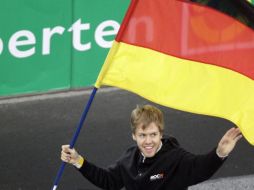 El campeón del mundo de Fórmula 1, Sebastian Vettel portando la bandera de su país. AP  /