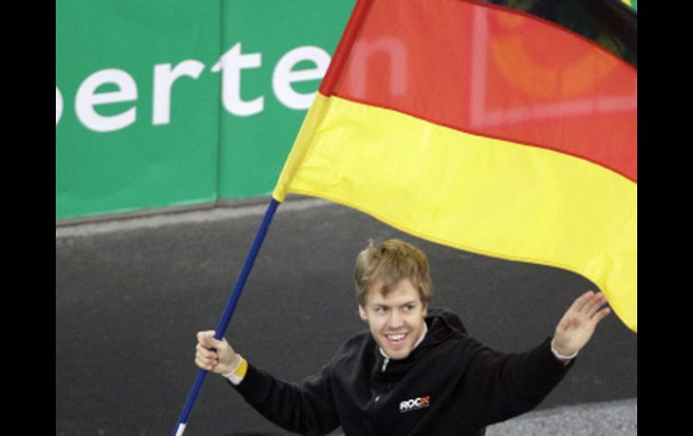 El campeón del mundo de Fórmula 1, Sebastian Vettel portando la bandera de su país. AP  /