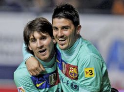 Messi es felicitado por el “Guaje” Villa, tras marcar uno de sus dos goles en la victoria del Barcelona. EFE  /