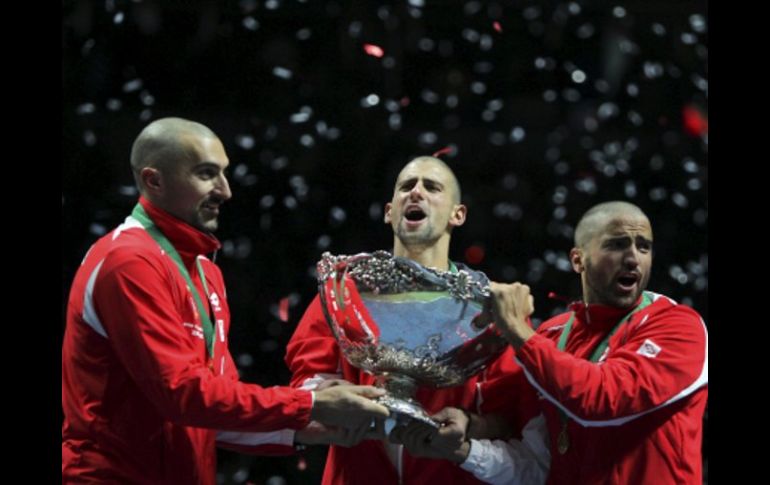 Los tenistas serbios Novak Djokovic (centro), Nenad Imonjic (izq) y Janko Tipsarevic celebran su triunfo. EFE  /