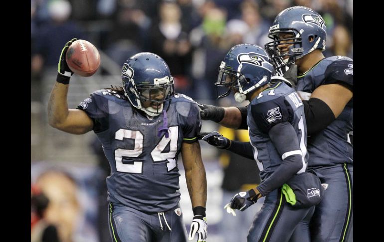 Marshawn Lynch es felicitado por sus compañeros al anotar para Seattle en elpartido de hoy. AP  /