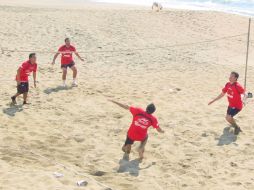 El técnico del Atlas, Benjamín Galindo (izq.), y sus muchachos, se dan tiempo para jugar en la playa. A. RAMÍREZ  /