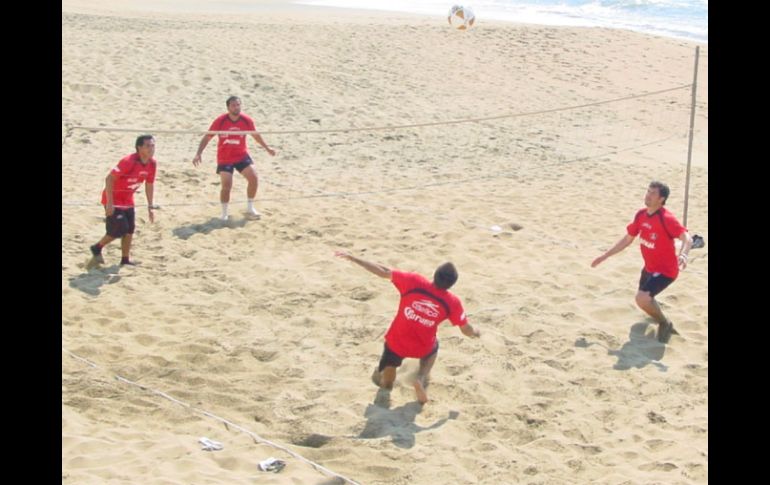 El técnico del Atlas, Benjamín Galindo (izq.), y sus muchachos, se dan tiempo para jugar en la playa. A. RAMÍREZ  /