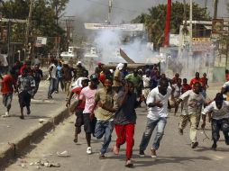 Haitianos corren por los gases lacrimógenos lanzados por las fuerzas de paz de la ONU. REUTERS  /