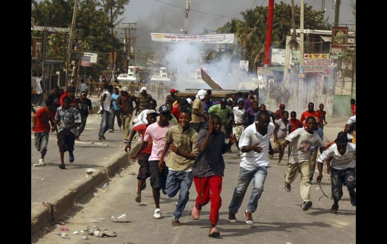 Haitianos corren por los gases lacrimógenos lanzados por las fuerzas de paz de la ONU. REUTERS  /