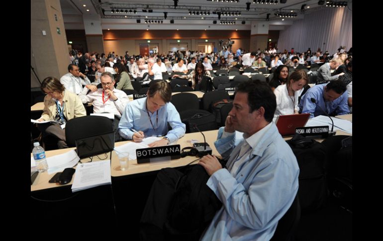 Delegados de varios países analizan documentos en el marco de las negociaciones de la conferencia de cambio climático. AFP  /