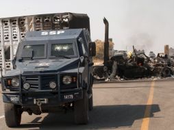 Un vehículo blindado Federal de la Policía mantiene una barricada incendiada en el bloqueo. AFP  /