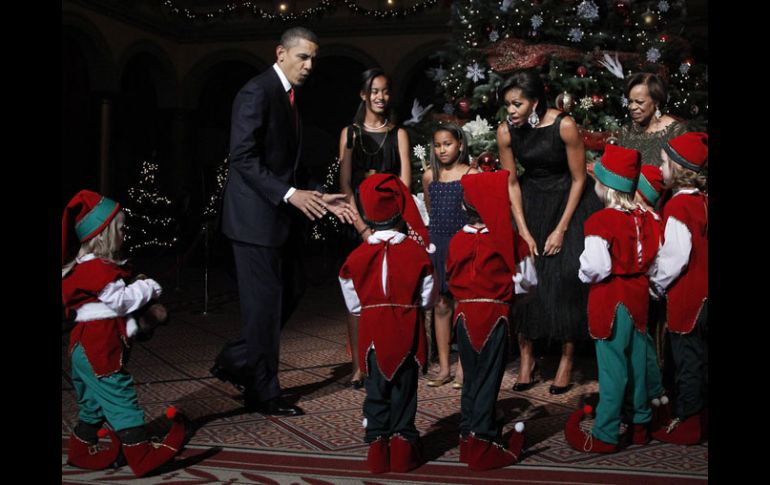 La familia Obama saluda a los niños vestidos de duendes en un acto navideño en el Museo Nacional de Washington. AP  /